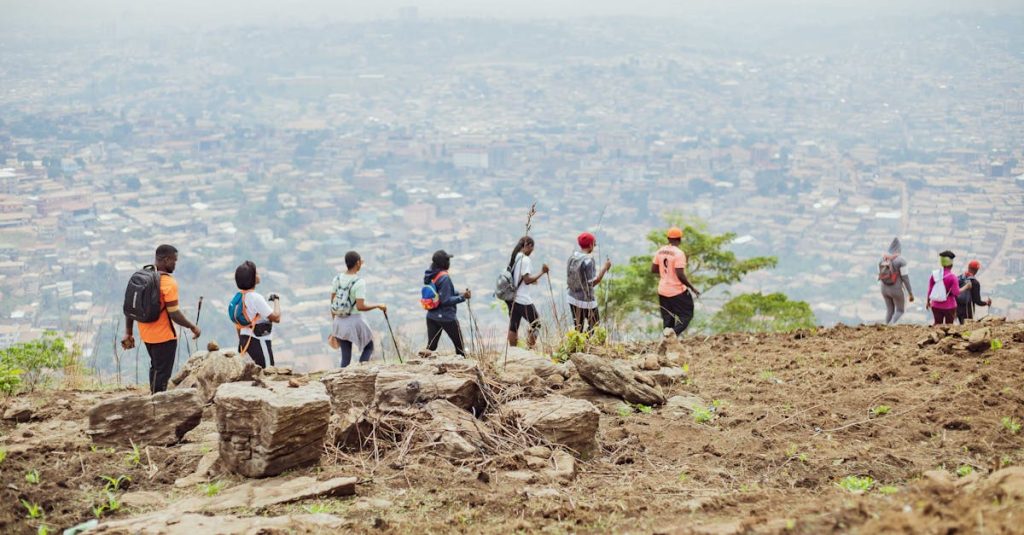 A group of hikers trekking on a rocky trail with a city view, showcasing adventure and teamwork.
